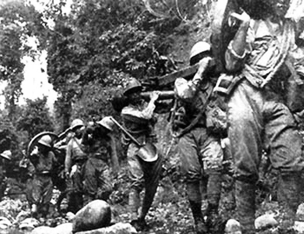 山砲を担いでココダ街道を進軍する日本兵